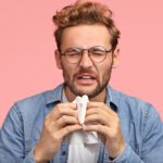 portrait-allergic-male-sneezes-all-time-rubs-nose-with-handkerchief-has-sick-look-suffers-from-cold-has-displeased-facial-exression-wears-denim-shirt-isolated-pink-people-disease-concept (1)