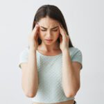young-beautiful-brunette-girl-frowning-touching-temples-headache-isolated-white-background